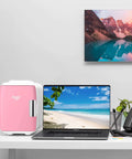 Dope Portable 4L Mini Fridge And Cooler Warmer placed on desk beside laptop, pink finish, 6 can capacity, USB AC DC ready