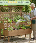 Man watering plants in a Two Tier Raised Garden Bed With Lattice Trellis For Outdoor Flowers And Veggies, 47.2 Inch Tall Wood Plant Stand.