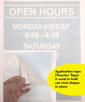 Custom Business Hours Window Decal Vinyl Lettering For Glass Doors In 10.5x13.5 Or 14x18 Inches With 11 Color Options Free Squeegee Included Super Easy Install Manual showing application tape being peeled off.