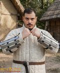 Person wearing medieval bracers for cosplay and reenactments, fully functional arm guards with splinted steel, outdoor setting