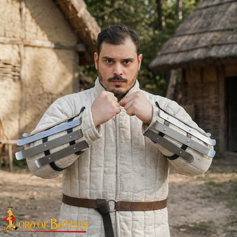 Person wearing medieval bracers for cosplay and reenactments, fully functional arm guards with splinted steel, outdoor setting