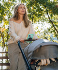 Woman pushing stroller with Stroller Phone Holder With MagSafe Handlebar Mount For On The Go, 20 N52 Magnets For A Strong, Secure MagSafe Grip