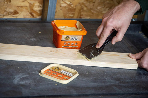 Gorilla All-Purpose Wood Filler, 16 oz tub, natural finish, applied to wood with putty knife