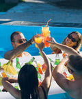 People enjoying drinks around an Inflatable Serving Bar Set 4 Pack For Pool Parties And Outdoor Buffets Ice Cold Salad And Appetizer Cooler Large