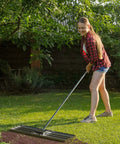 Person using Heavy Duty Lawn Leveling Rake 35 Inch With Stainless Steel Build And Full Welded Design Pro Grade Yard Care Tool in garden
