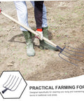 Person using Heavy Duty Manure Fork With Four Tines And Hardwood Handle A Rugged All Purpose Farm Tool For Garden And Lawn Maintenance Built For Yard Work And Reliable Performance A True Workhorse on dirt