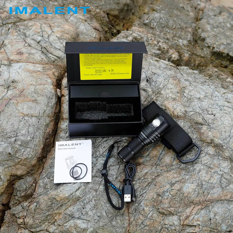 Ultra Bright EDC Flashlight 13000 Lumens, Rechargeable Pocket Light For Camping And Hiking, Emergency Prep, USB C Recharge, Compact 4.5 Inch Size, Long Lasting Battery shown with packaging and USB-C cable on rocky surface