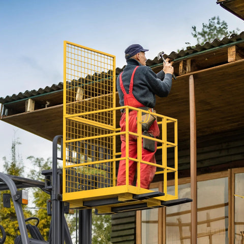 Forklift safety cage; side view of yellow metal cage with mesh panels mounted on forklift for elevated work.