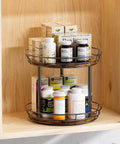 10 Inch Lazy Susan Turntable Organizer 2 Tier Round Rotating Spice Rack with wood base and black metal frame in kitchen cabinet.