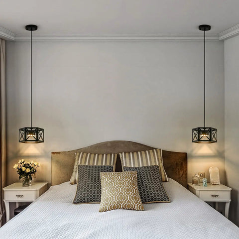 Bedroom setting with two farmhouse pendant lights with wood and metal cage, rustic white wood pendant with glass above nightstands.