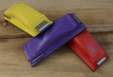 Ergonomic Sanding Block For Wet Or Dry Sanding Easy Load Plain Paper Sander Complete Five Color Code Hand Sanders Set in yellow, purple, and red on wood surface.