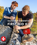 ThriAid mini first aid kit in a red hard-shell case with white cross logo, outdoors with hikers.