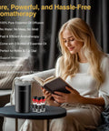 Woman with book next to No Water Needed Nebulizing Diffuser Starter Kit With Battery Powered Mini Scent Machine Including 3x20ml Essential Oils