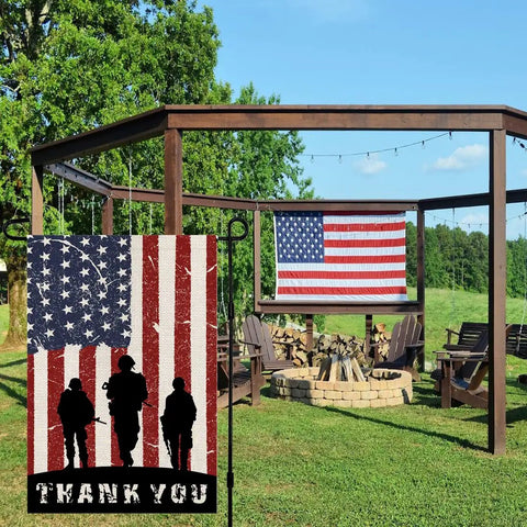 American Soldier Thank You Garden Flag 12x18 Burlap Double Sided For Fourth Of July Independence Day Memorial Day Yard Outdoor Decor USA Flags Weather Resistant Durable Sleeve Hanger Fits Standard Flag Stands displayed in garden, showing silhouettes of soldiers and 'Thank You' text with large American flag in background on gazebo.
