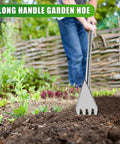 2-In-1 Garden Hoe And Weed Rake With Adjustable Long Handle being used in a garden, showing stainless steel cultivator head.