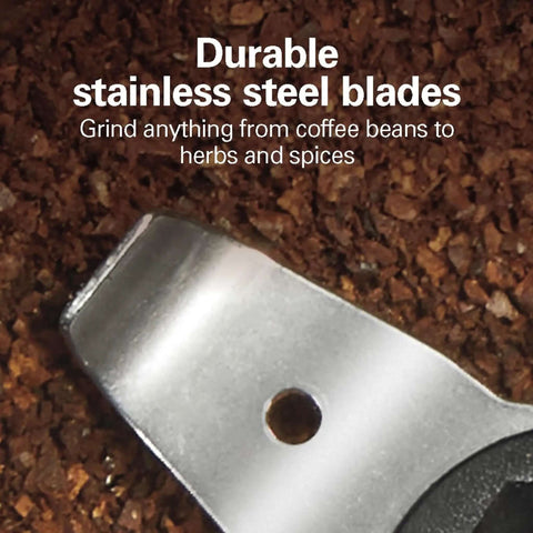 Close-up of stainless steel blades in the Fresh Grind Electric Coffee Grinder for Beans, Spices, and More with ground spices background.