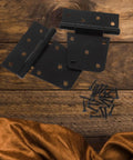 Beefy 3.5 Inch Black Gate Hinges 2 Pack Weld On Heavy Duty Gate Hardware For Wood Fences with included screws on wooden background
