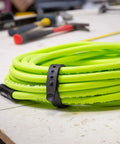 All Purpose Utility Strap 18 Inch Tie Down With 70 Lb Load Capacity holding neon green cable on workbench