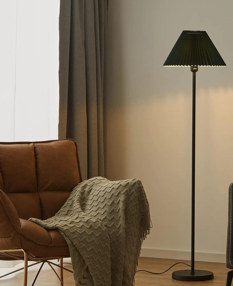 Must Have Black Pole Floor Lamp With Adjustable Height And Dark Green Shade, Metal Base, LED Bulb Included, stands by armchair.