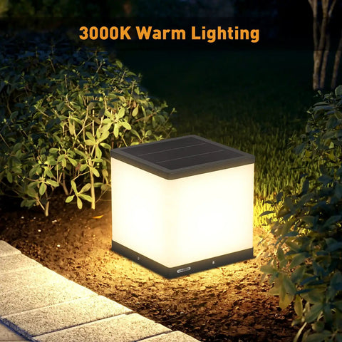Outdoor Solar Post Cap Light with Warm 3000K LED illuminating a garden area at night, IP54 waterproof, die-cast steel.