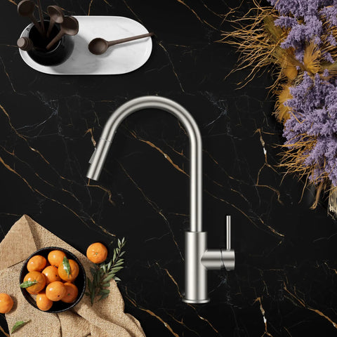 Brushed Nickel Kitchen Faucet With Pull Down Sprayer High Arc Gooseneck Spout against black marble countertop with oranges and flowers