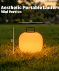 Cordless RGBW LED Table Lamp With Remote Control, Portable Outdoor Lantern on grass at sunset, mini version lit up