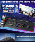 RGB Wireless Charging Gaming Mouse Pad With Dual 15W Fast Chargers Ultra Smooth Surface Non Slip Desk Mat With Phone Earbuds And Watch Charging Zones Ideal For Gamers And Home Office Setups on desk with monitors and keyboard.