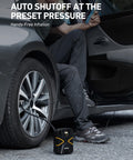 Man using Portable 12V Digital Tire Inflator With Auto Shutoff on car tire, showing real time pressure display, preset tire pressure.