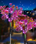 Outdoor Solar Flower Lights Set Phalaenopsis Orchid Solar Garden Lights Waterproof IP65 2 Pack glowing in a garden at night