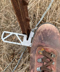 Heavy Duty Aluminum T Post Fence Step With Integrated Nylon Pouch Rock Solid Grip on a T post with a boot stepping on it.
