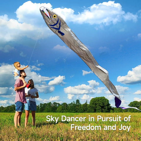 Family flying Massive 61ft Silver Soft Parafoil Beltfish Kite With Reel in a grassy field against blue sky.