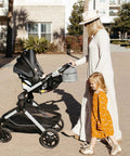 Keep It Chill On The Fly Breastmilk Bottle Cooler Travel Bag With Included Freezing Insert attached to stroller on a sunny day.