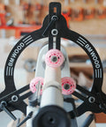 Front view of BMWOOD Woodturning Steady Rest MC-FS7 on a lathe with black frame and pink roller wheels.