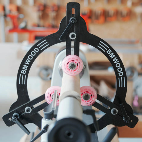 Front view of BMWOOD Woodturning Steady Rest MC-FS7 on a lathe with black frame and pink roller wheels.