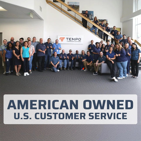 Group of employees by Tempo Communications sign, American Owned, U.S. Customer Service banner in office setting