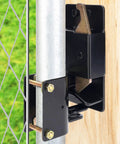 Close-up view of Heavy Duty Two Way Gate Latch mounted on a post, designed for secure farm fencing and livestock pens.