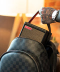Person placing Spark MINI 10W Portable Guitar Amp And Bluetooth Speaker into a backpack, showing portability and ease of use.
