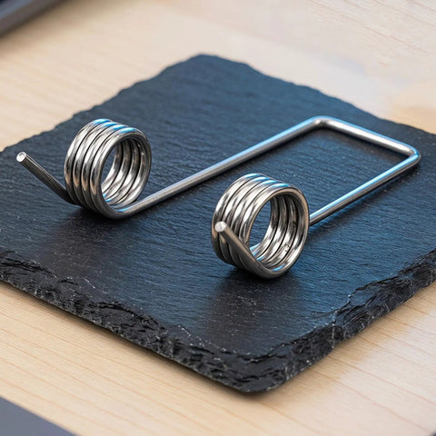 Heavy Duty Double Leg Torsion Springs For Trash Can Lid Repair Kit with 4 Coils Stainless Steel Garbage Bin Accessories Strong 130 Degree Angle Heavy Gauge Wire To Fix Stuck Lids Fast And Easy, shown on slate
