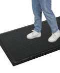 Person standing on Heavy Duty Anti Fatigue Floor Mat Built For Long Shifts 3 Ft By 7 Ft Thick Fifteen Sixteenths Inch Ergonomic Standing Mat.