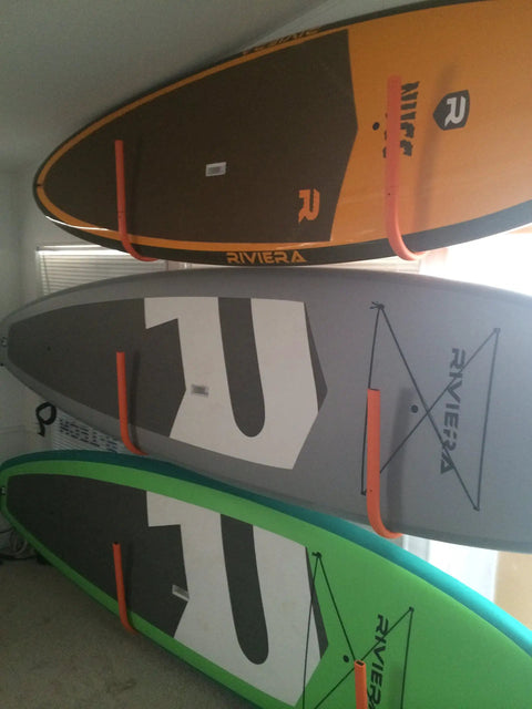 Wall Mounted Snowboard Surfboard Rack Set Vertical Wall Hanger showing three SUP boards with vibrant colors, securely held by durable foam cradles.
