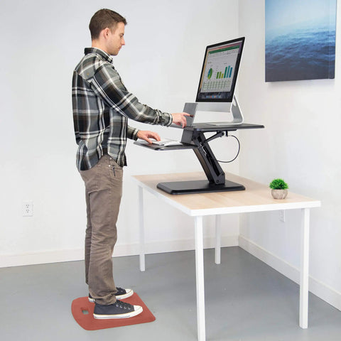 Man using Anti Fatigue Standing Desk Floor Mat For Home Office Kitchen Garage Red 18x22 Inch Rubberized Gel Foam Non Slip Washable Surface