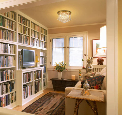 Living room with Three Light Crystal Chandelier With Brass Finish Flush Mount Ceiling Light Fixture, bookshelf, and cozy seating area.