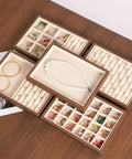 Slick Walnut Wood Jewelry Display Tray With Dope 24 Compartments For Rings Earrings Necklaces with assorted jewelry inside.