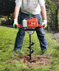 Person using Gas Powered 72cc Post Hole Digger With Two Stroke Engine in garden with 6 Inch auger bit, digging hole in grass.