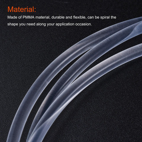 Close-up of clear PMMA fiber optic cable on a black surface; translucent flexible tubing