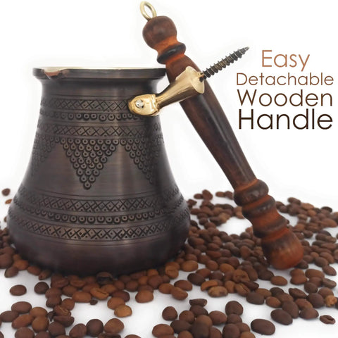 XXL Copper Cezve Coffee Pot With Wooden Handle, Hand Engraved And Hammered Solid Copper Ibrik Briki For Stovetop Turkish Greek Arabic Coffee, 28 Fl Oz Old School Antique Vibe Pro Grade with detachable wooden handle on coffee beans.