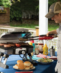 Man grilling burgers with Stainless Steel 3 Piece BBQ Grilling Tool Set With Spatula Fork And Tongs Plus Bonus Grill Glove