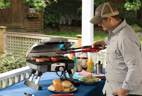 Man grilling burgers with Stainless Steel 3 Piece BBQ Grilling Tool Set With Spatula Fork And Tongs Plus Bonus Grill Glove
