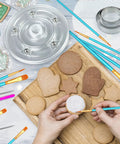 123 Piece Cookie Decorating Kit With Large Acrylic Turntables Non Slip Silicone Mats Piping Bags And Detailed Decorating Brushes For Cakes Cupcakes in use with decorated cookies