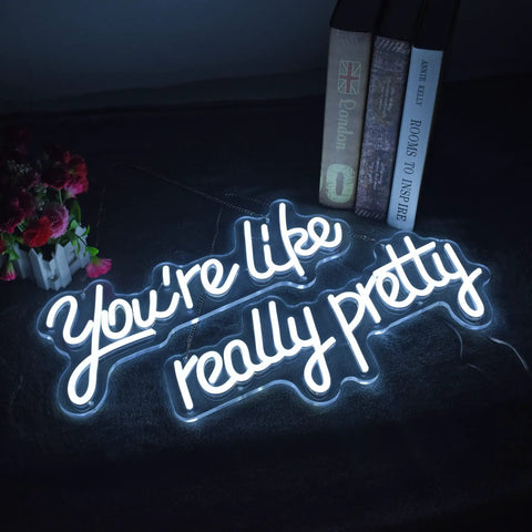 "Youre Like Really Pretty White LED Neon Sign For Wall Decor With Adjustable Brightness Levels Dope Vibe For Bachelorette Party Engagement Wedding Bar Birthday Party Home Cave Pub Restaurant" glowing in dark with books